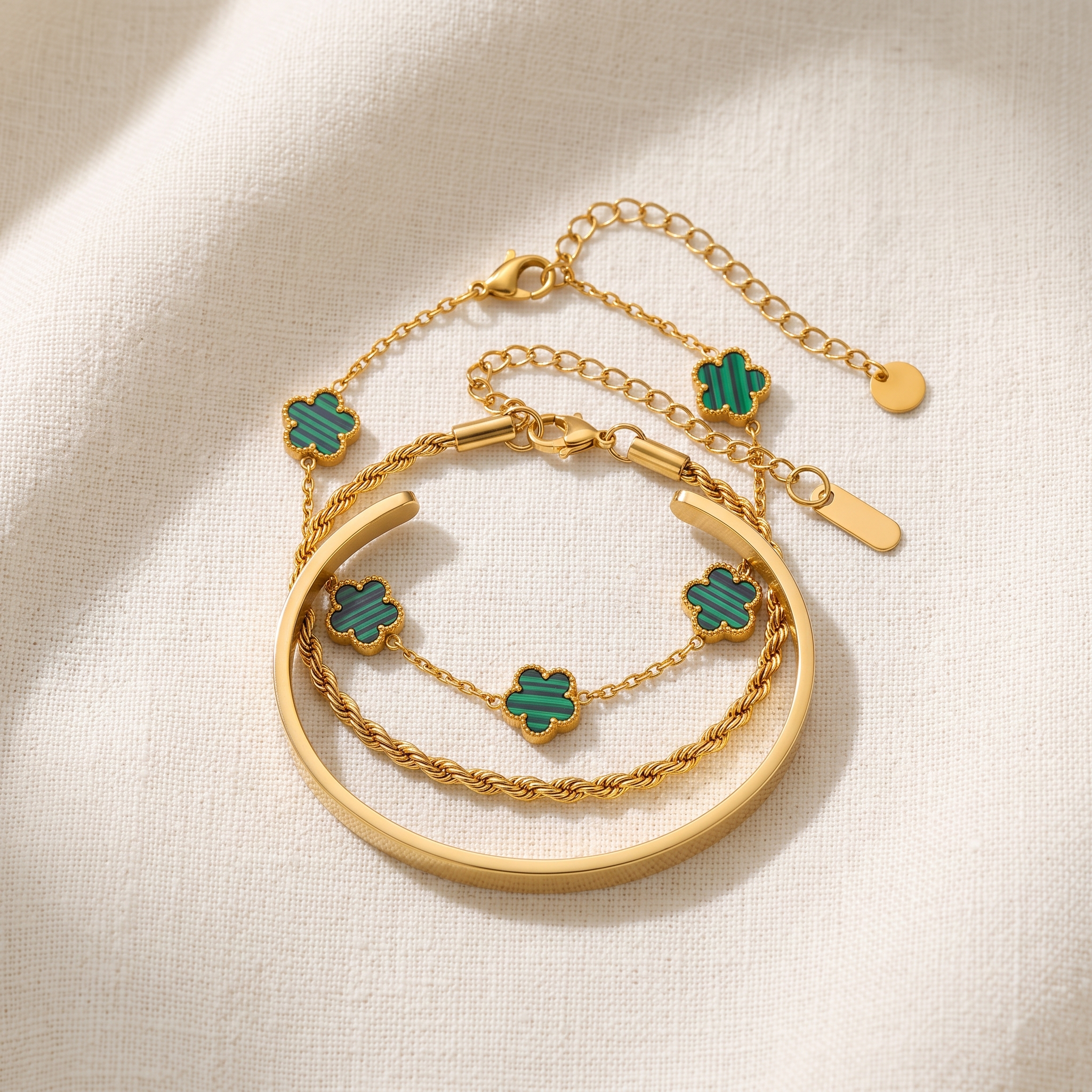 The Versailles Stack — three-piece gold bracelet set worn together: clover, rope chain and cuff