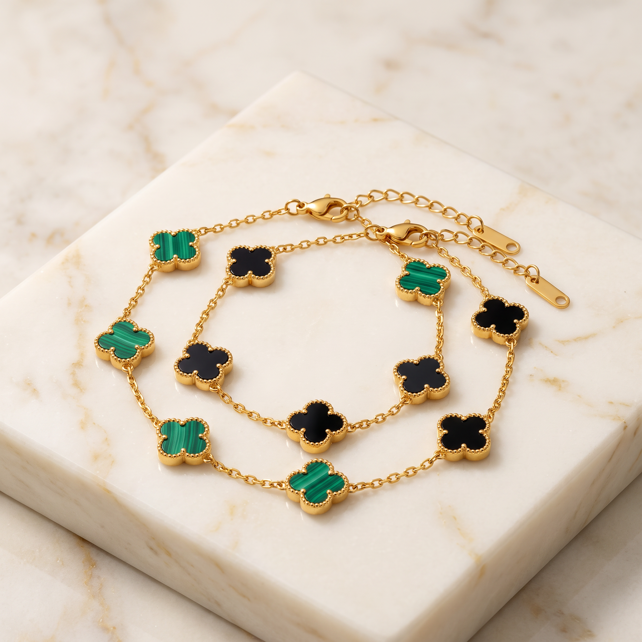 The Day & Night Duo — green and black clover bracelets on cream marble